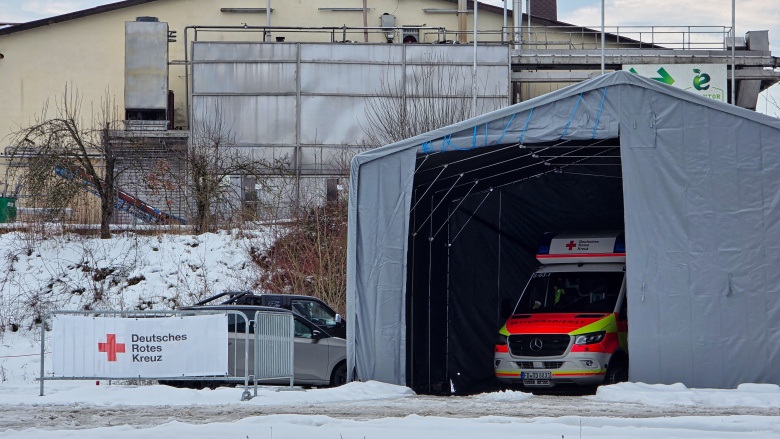 Zelthalle mit großer Öffnung, in der ein Rettungswagen zu sehen ist. Links ein Banner mit der Beschriftung "Deutsches Rotes Kreuz". Auf dem Boden Schnee.