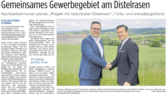 Die Bürgermeister Gärtner und Möller reichen sich die Hand auf einer Wiese am Diselrasen 